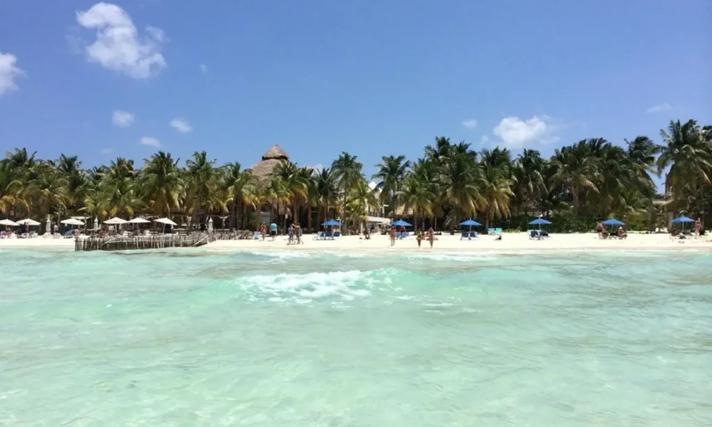 Palm trees and beach umbrellas line the sunny shore of Cancún.