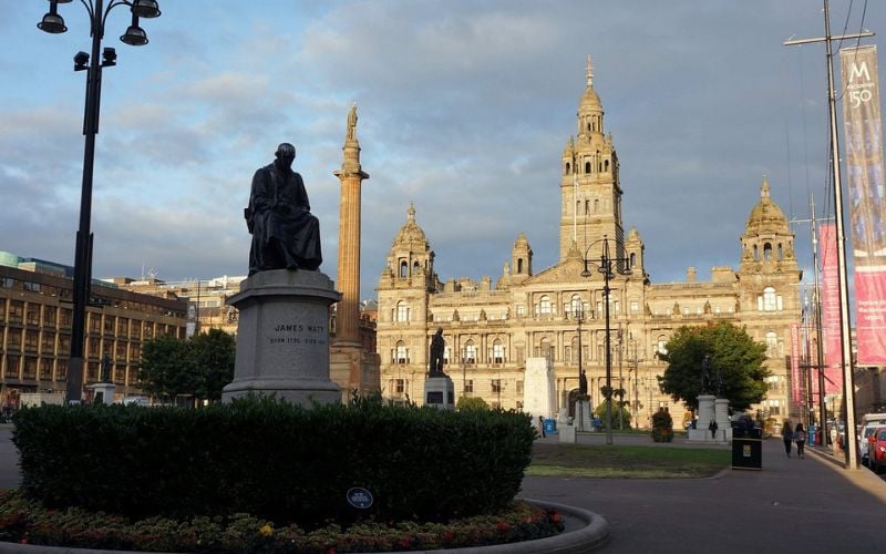 George Square in Glasgow with a statue of James Watt and the City Chambers in the background.