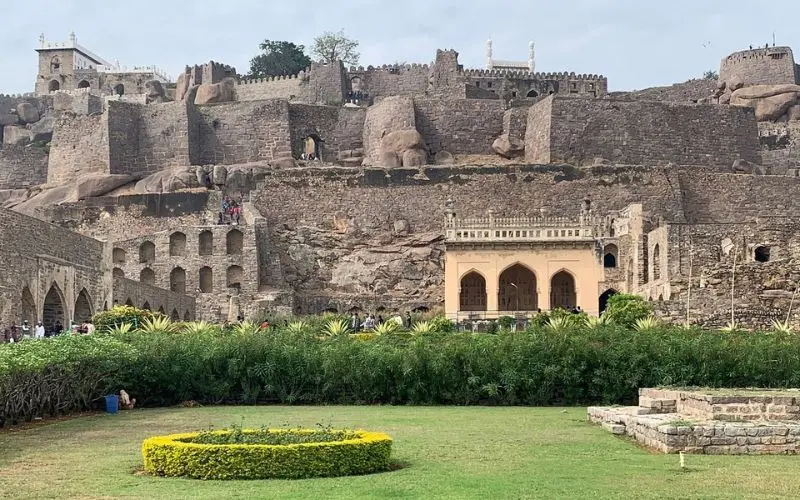 Hyderabad with the stone walls and arches of Golconda Fort against a clear sky.