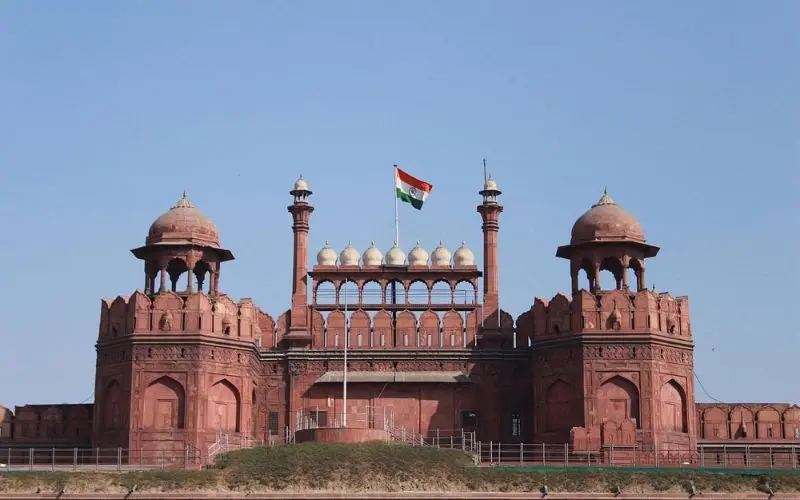 Delhi with the Red Fort’s red sandstone walls and domes under a clear blue sky.