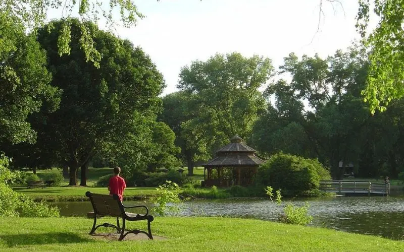 Park scene with a pond, gazebo, and a person in a red shirt in Middleton.