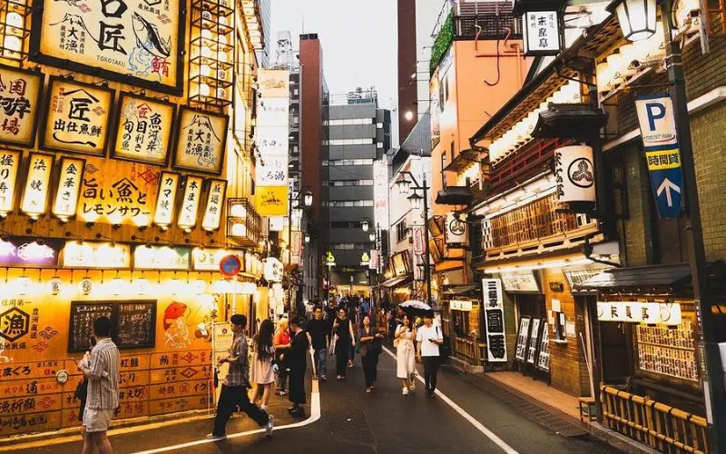 Street in Tokyo glowing with lantern signs during the evening.