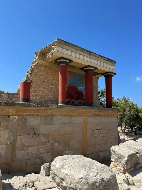 Ancient ruins with red columns at the Palace of Knossos.