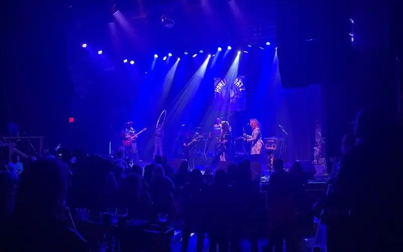 The Fox Theatre shows a live band performing under blue stage lights.