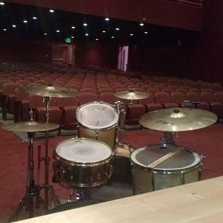 Drum set on stage facing empty seats at the Carver Theater.