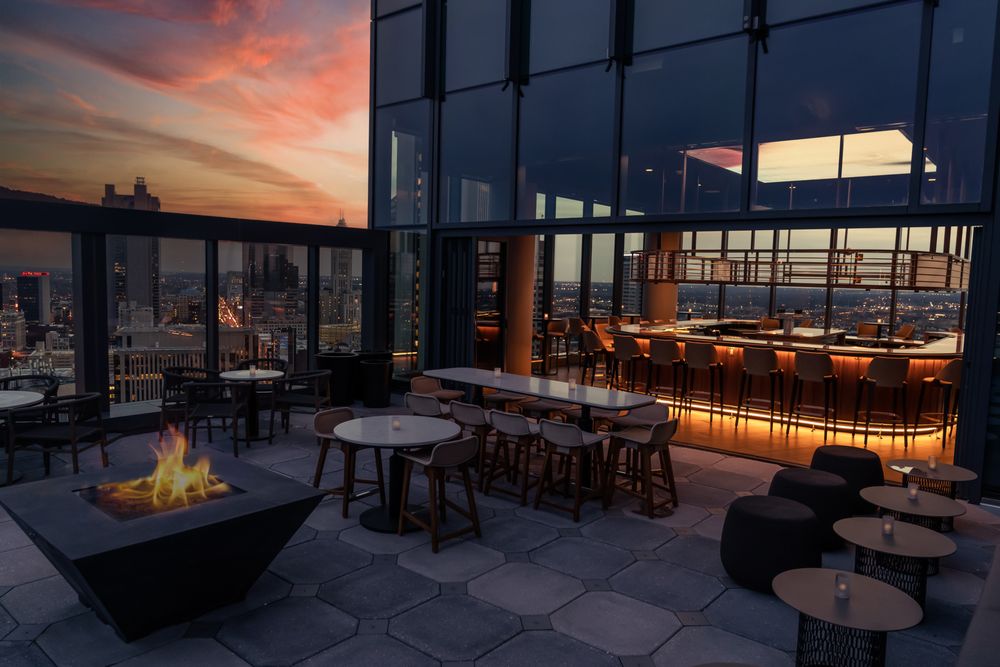 Rooftop bar Stories on High at sunset with city views, outdoor seating, and a fire pit.