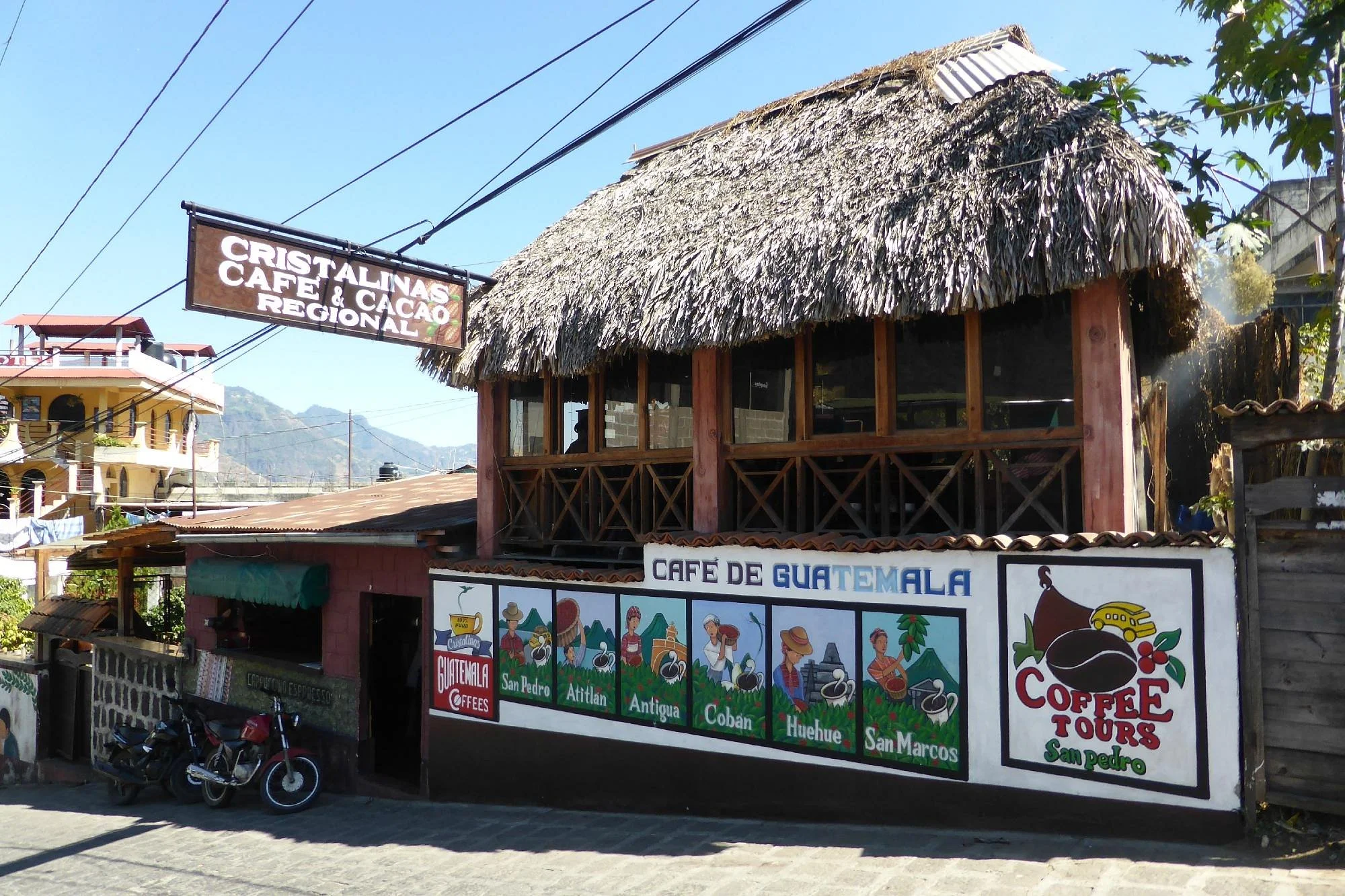 Cristalinas Cafe & Cacao Regional traditional thatched roof building in San Pedro La Laguna with colorful Guatemala coffee mural