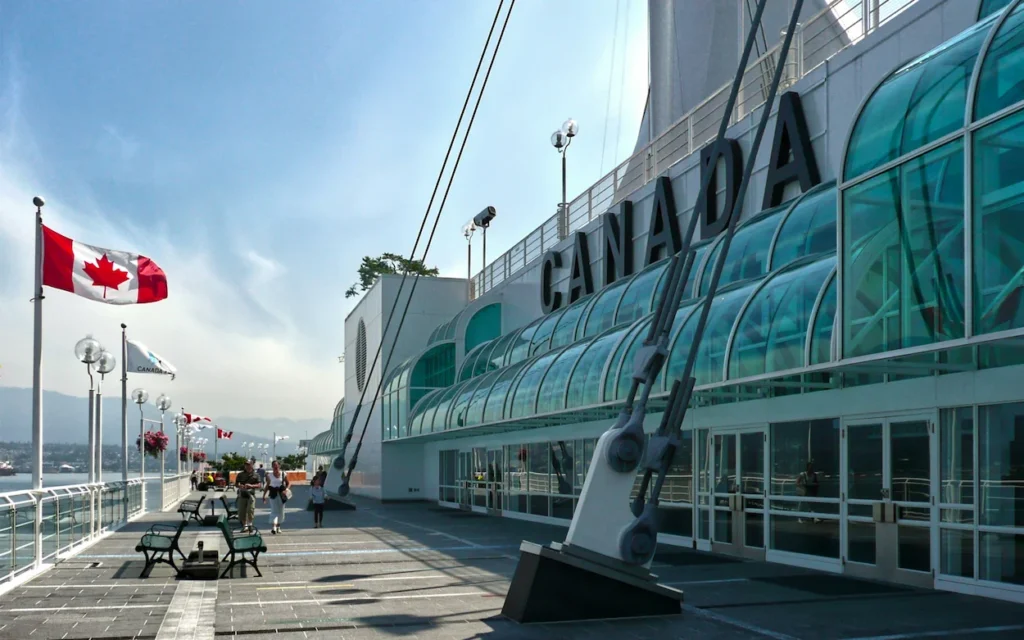 Canada Place in Vancouver with the Canadian flag flying alongside the glass building structure