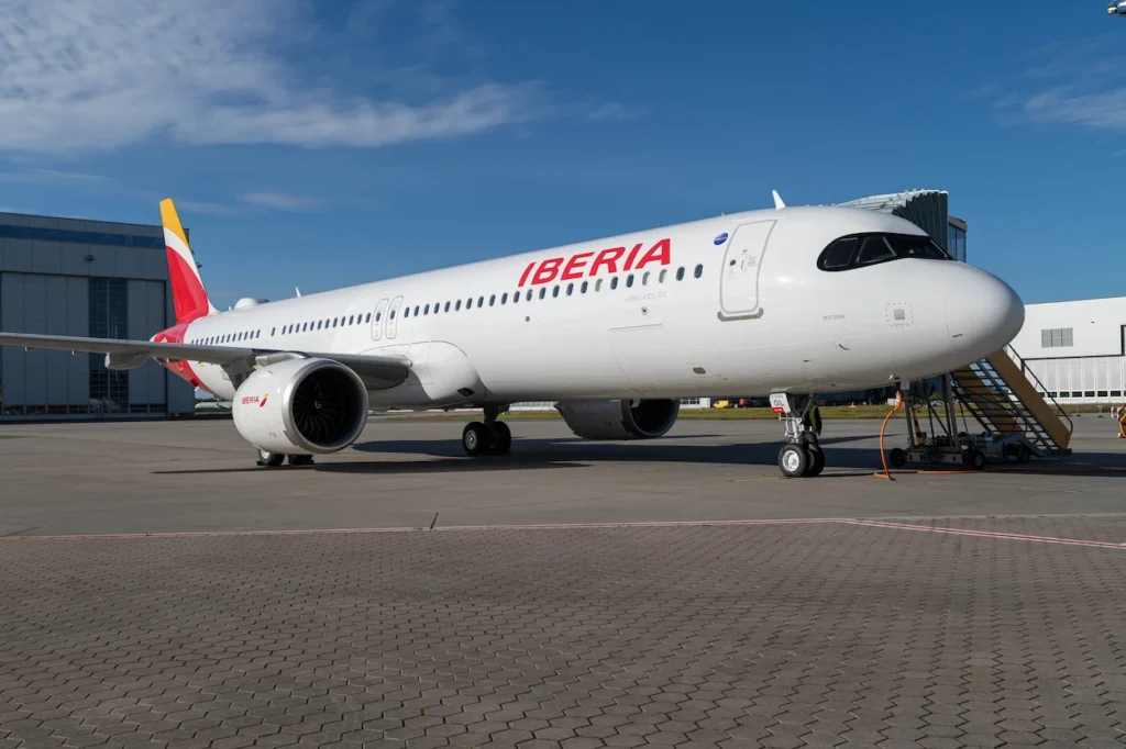Iberia Airbus A321XLR passenger plane parked on a paved airport tarmac next to mobile stairs
