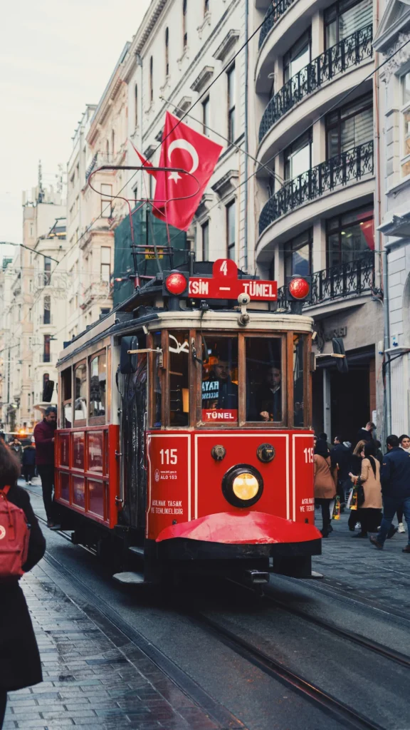 Historic red tram moving down pedestrian tracks on Istiklal Avenue