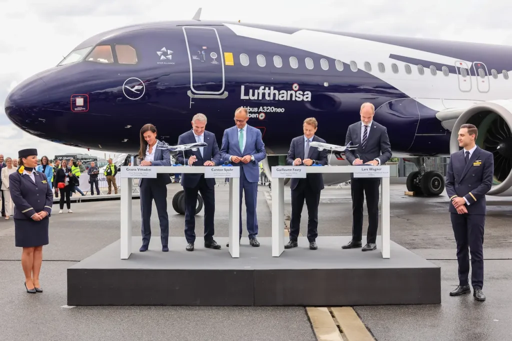Lufthansa and Airbus executives sign an agreement in front of the new Airbus A320neo