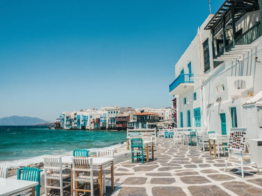 Waterfront patio restaurant with white and blue chairs in Little Venice, Mykonos