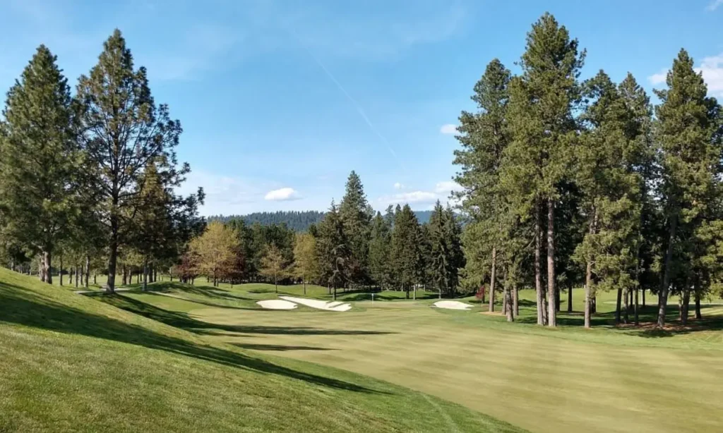 The lush green fairways and sand bunkers of Coeur d'Alene Resort Golf Course on a sunny day.