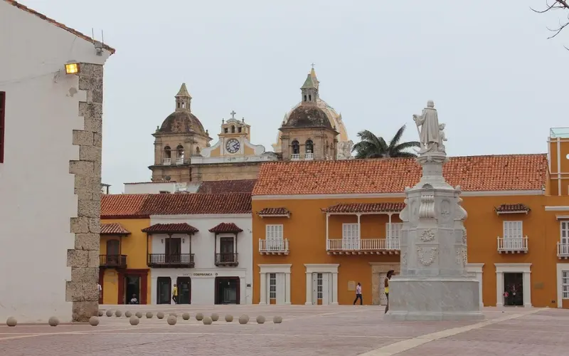 Colombia features a colonial square with a statue and church domes.
