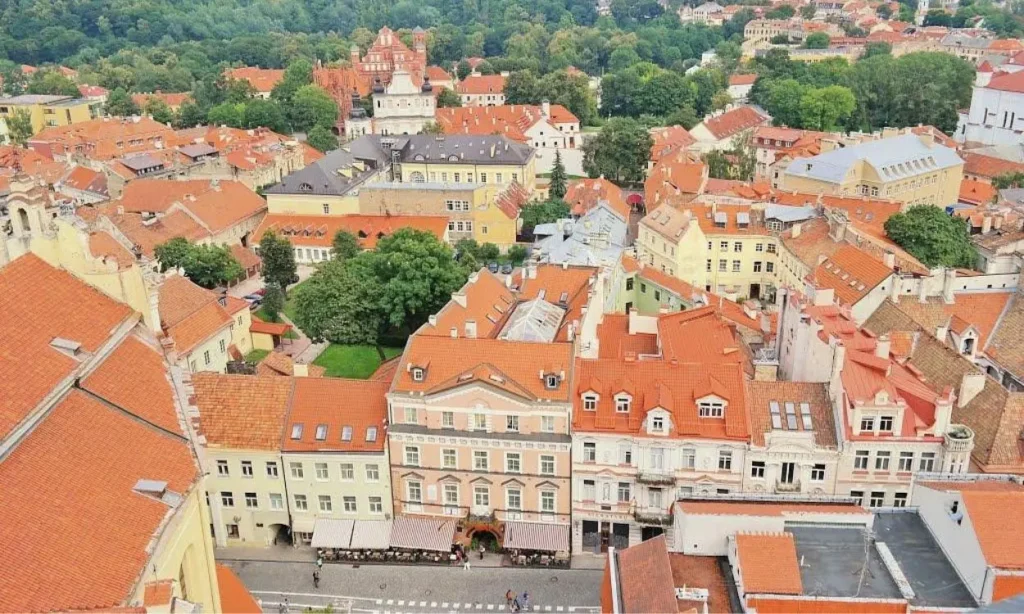 An aerial view of Lithuania’s old town with red rooftops and green trees.