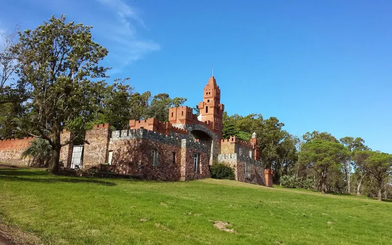 Uruguay shows a red brick castle surrounded by green grass.