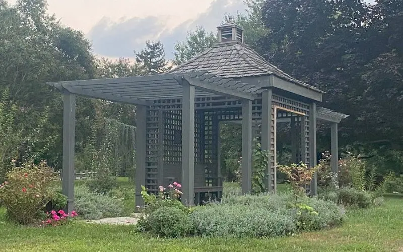A wooden gazebo surrounded by flowers at Strawbridge Lake Park.