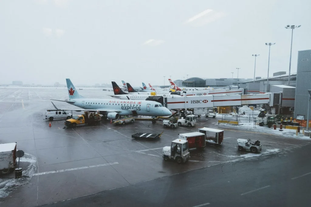 A regional passenger jet parked at a snowy airport terminal gate