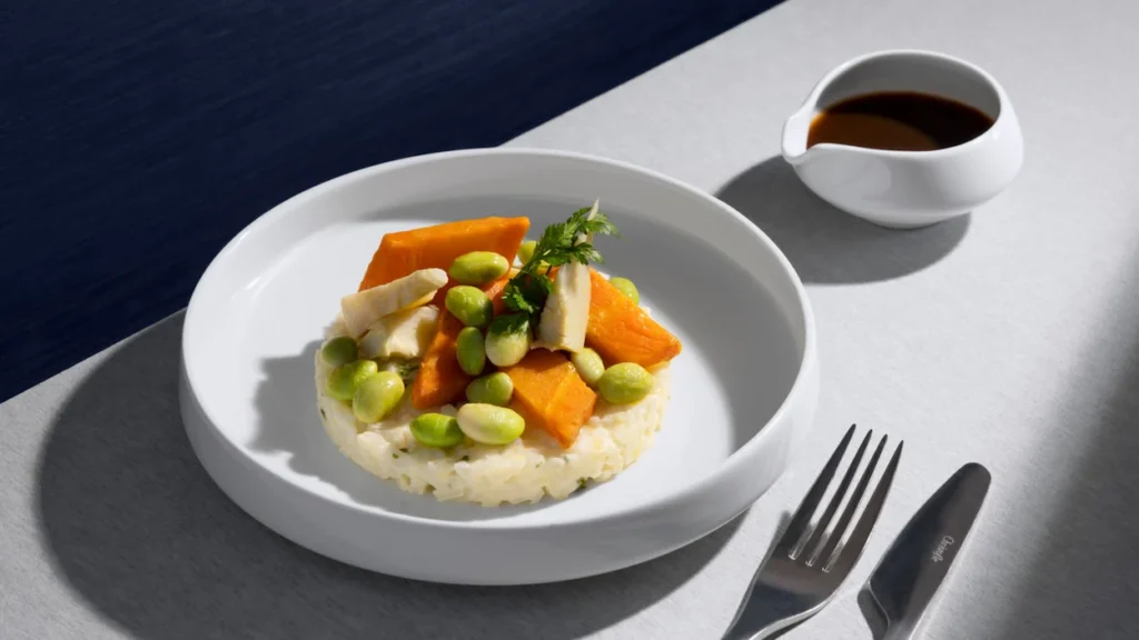 Air France inflight business class meal of rice risotto topped with sweet potato, edamame, and a side of sauce