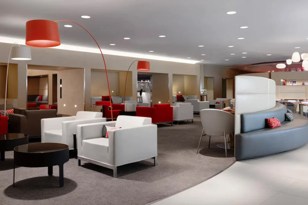 Air France La Première airport lounge seating area with white armchairs and red floor lamps