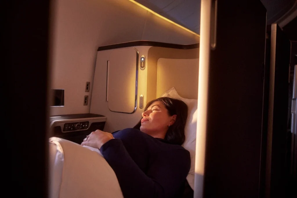 Passenger sleeping in a private British Airways business class suite
