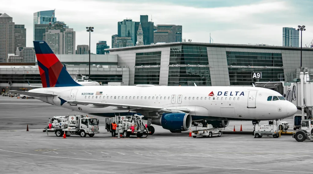 A Delta Air Lines Airbus A320 passenger airplane parked at a terminal boarding gate in Boston