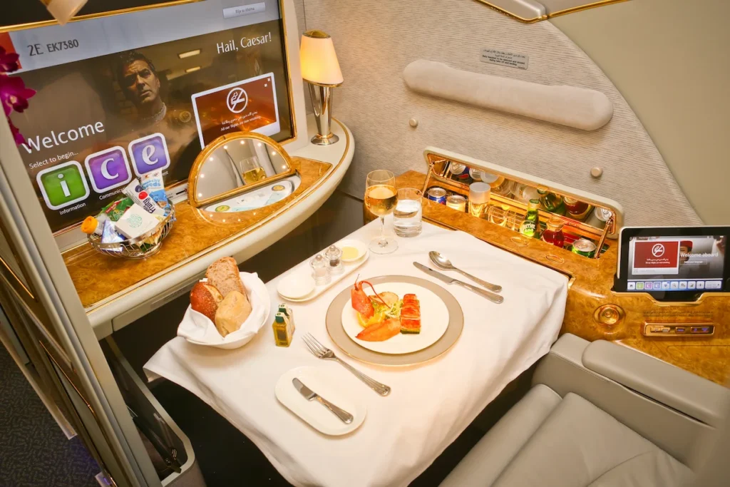 Gourmet multi-course meal set on a white tablecloth inside an Emirates First Class suite