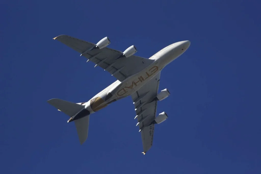 Underbelly view of an Etihad Airways Airbus A380 double-decker airplane