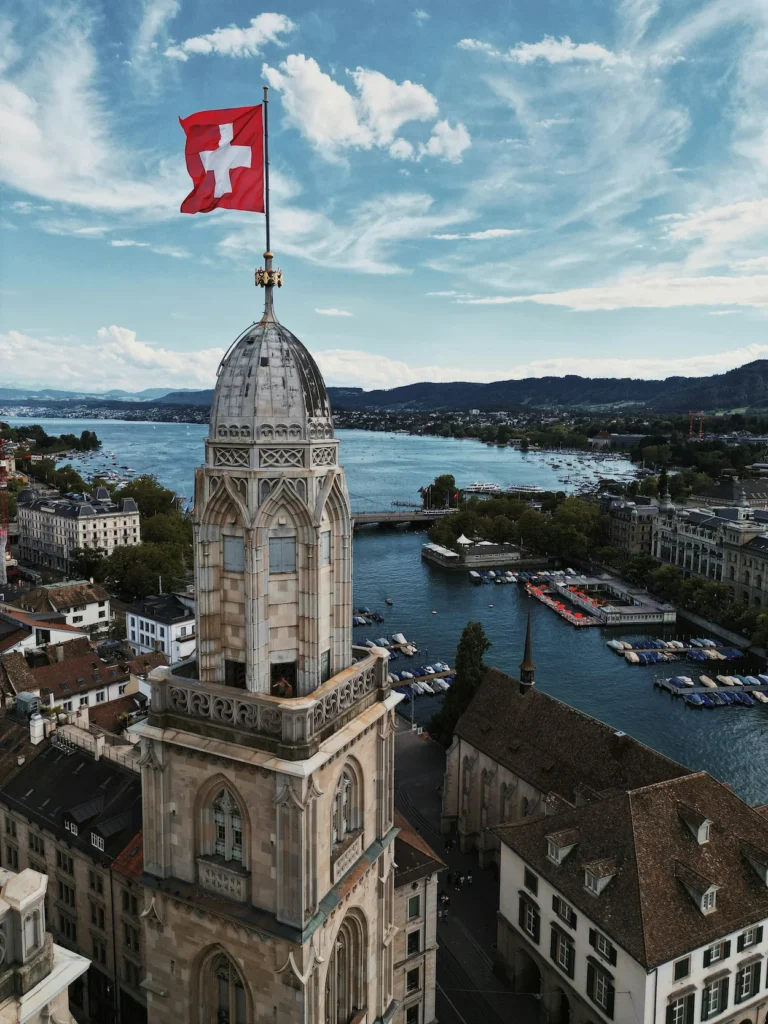 Grossmünster church tower flying a Swiss flag overlooking Lake Zurich