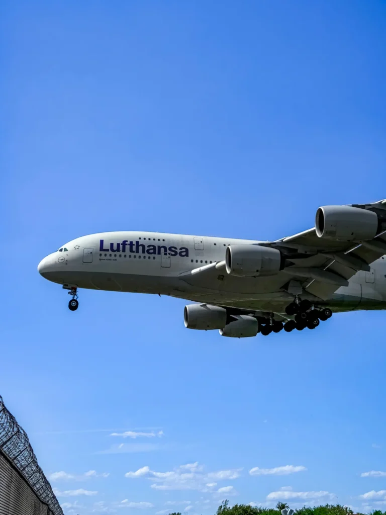 Lufthansa Airbus A380 double-decker passenger airplane flying low overhead during landing