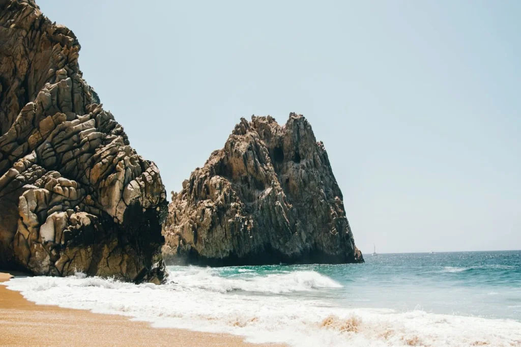 Crashing waves on Divorce Beach in Cabo San Lucas with large sea stack rock formations