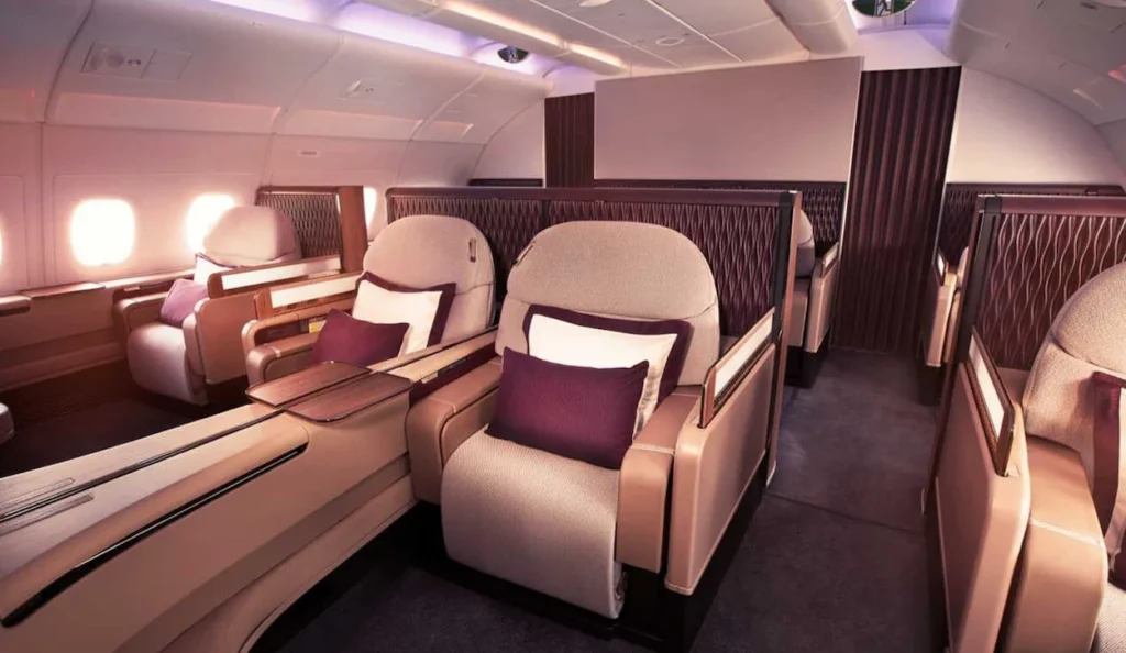 Empty cream and plum fabric passenger suites inside the open-plan Qatar Airways A380 First Class cabin