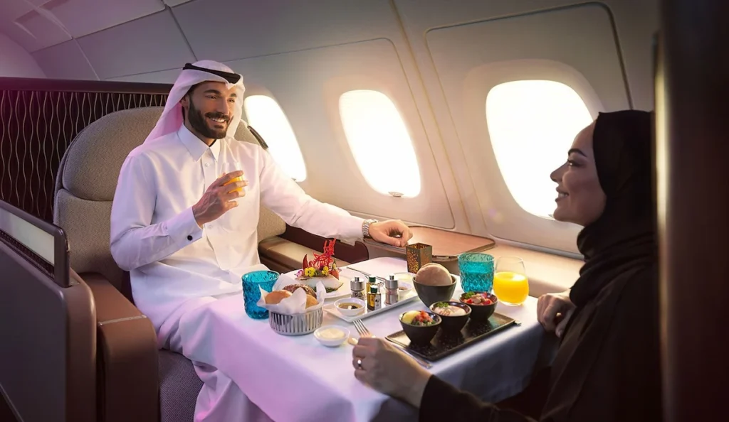 A Arab couple enjoying a fine dining meal together inside a Qatar Airways A380 First Class suite