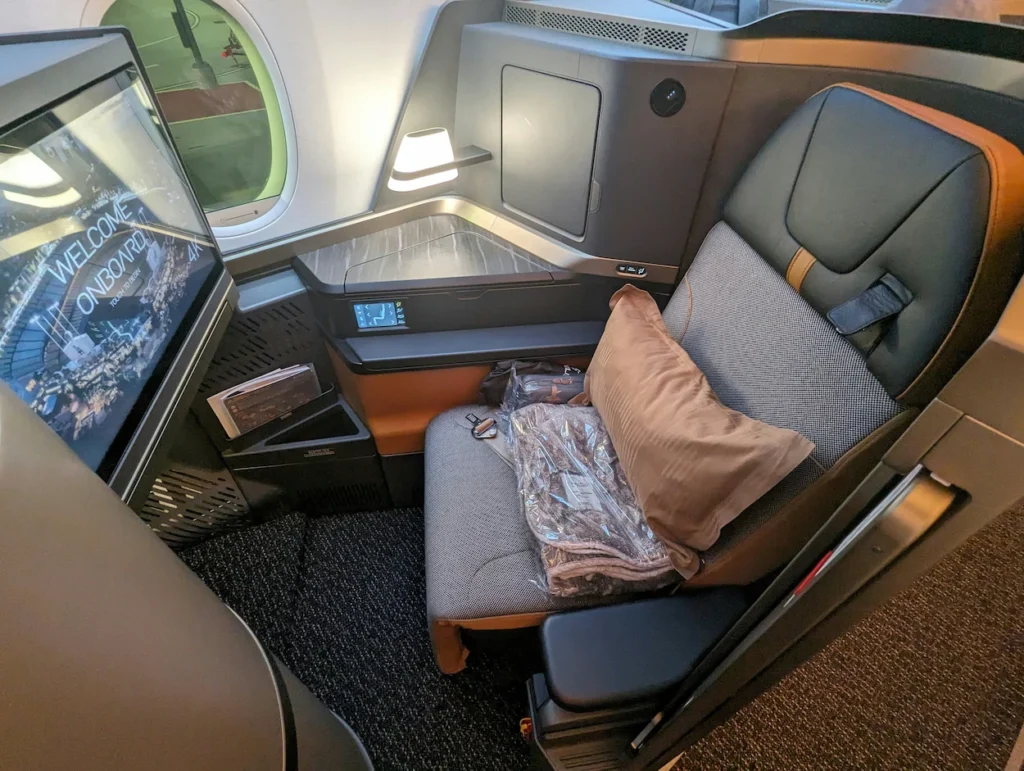 Starlux Airlines business class seat with brown pillow and 4K entertainment screen