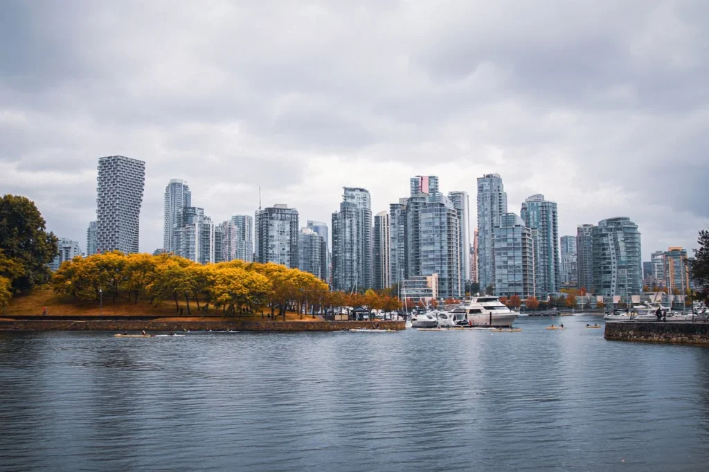 Vancouver skyline with glass skyscrapers and fall trees along False Creek