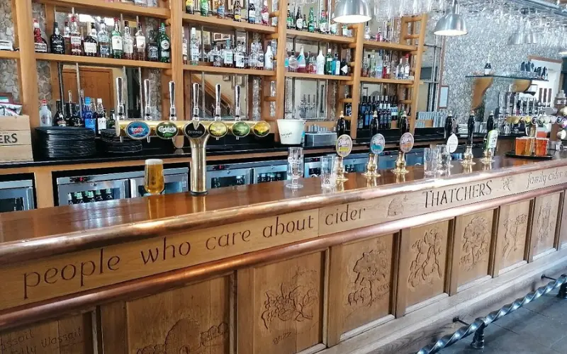 Wooden bar with cider taps at Thatchers.