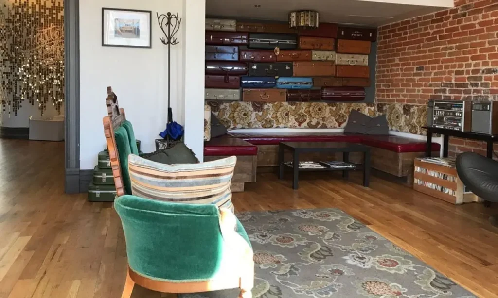 Stylish lounge with vintage suitcases on the wall and a mix of retro seating.