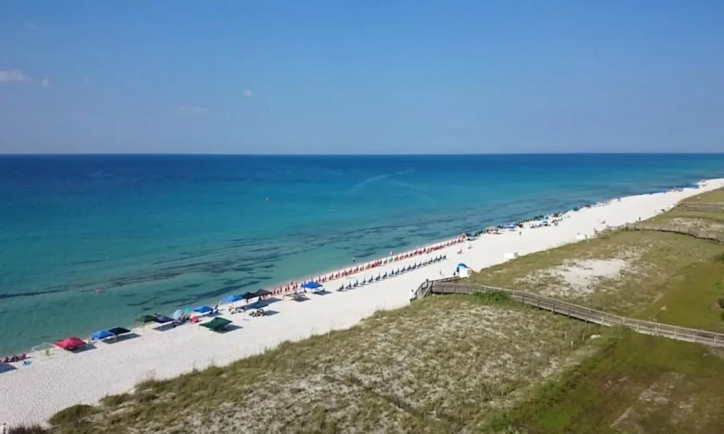 A long stretch of white sand and clear water at Navarre Beach, Florida.