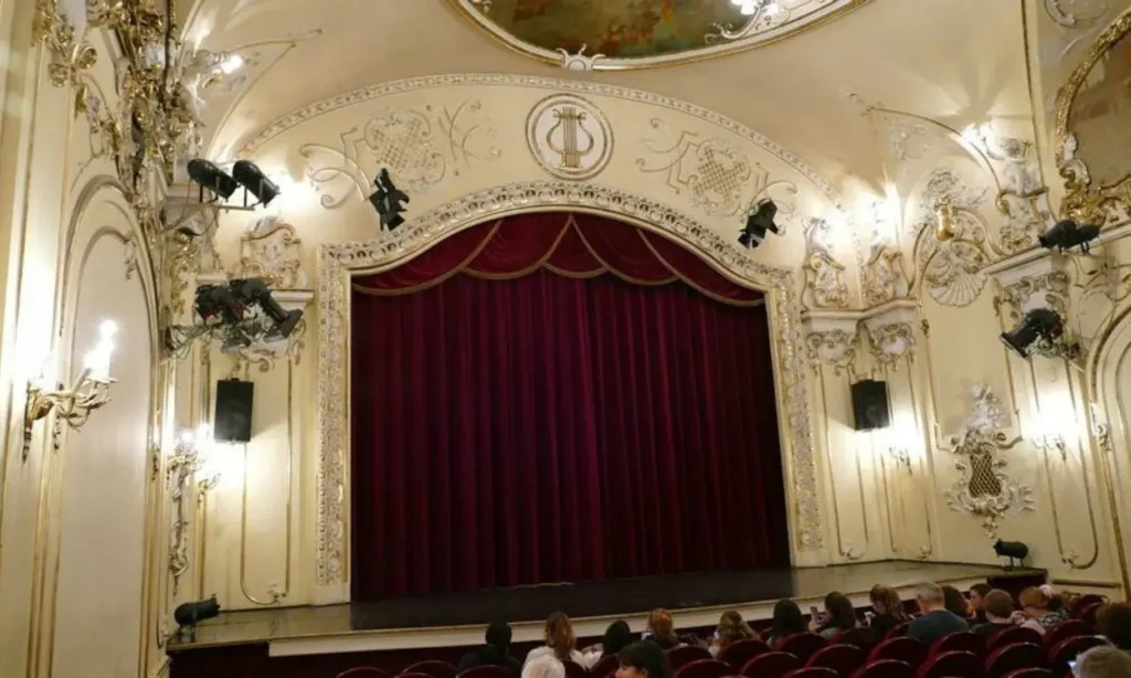 The elegant stage with red curtains inside the Danube Palace theater.
