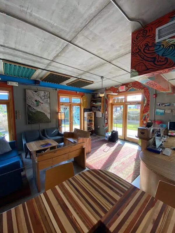Modern, sunlit common area with wooden furniture and colorful decor.