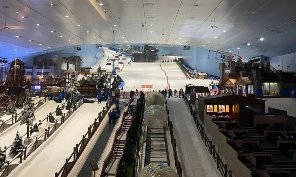 The indoor ski slopes and play areas at Ski Dubai with people enjoying the snow.