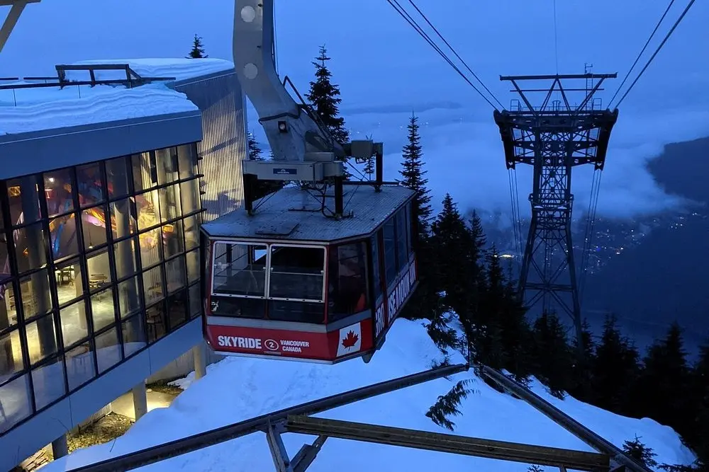 The Skyride gondola at Grouse Mountain overlooking Vancouver at dusk.