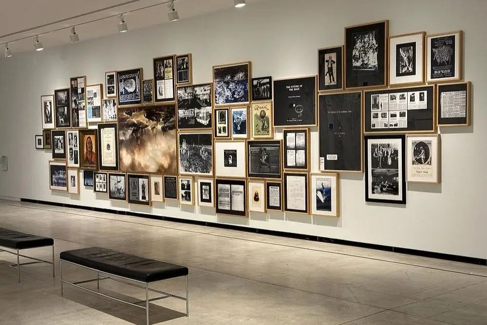 A wall of framed photographs and artwork inside the Vancouver Art Gallery.