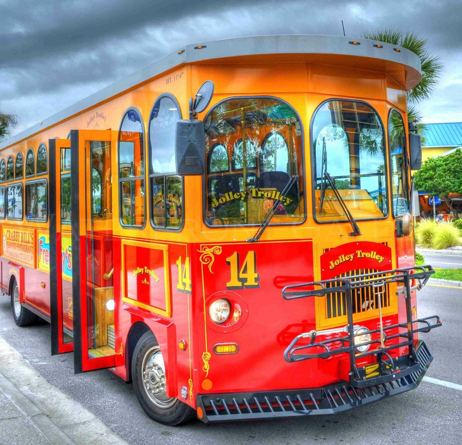 Bright red and yellow Jolley Trolley bus number 14 parked curbside, ready to welcome passengers.