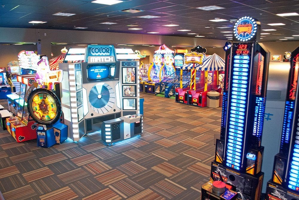 GameTime arcade with rows of brightly lit machines, including Color Match, ticket games, and carnival-style attractions inside a large entertainment center