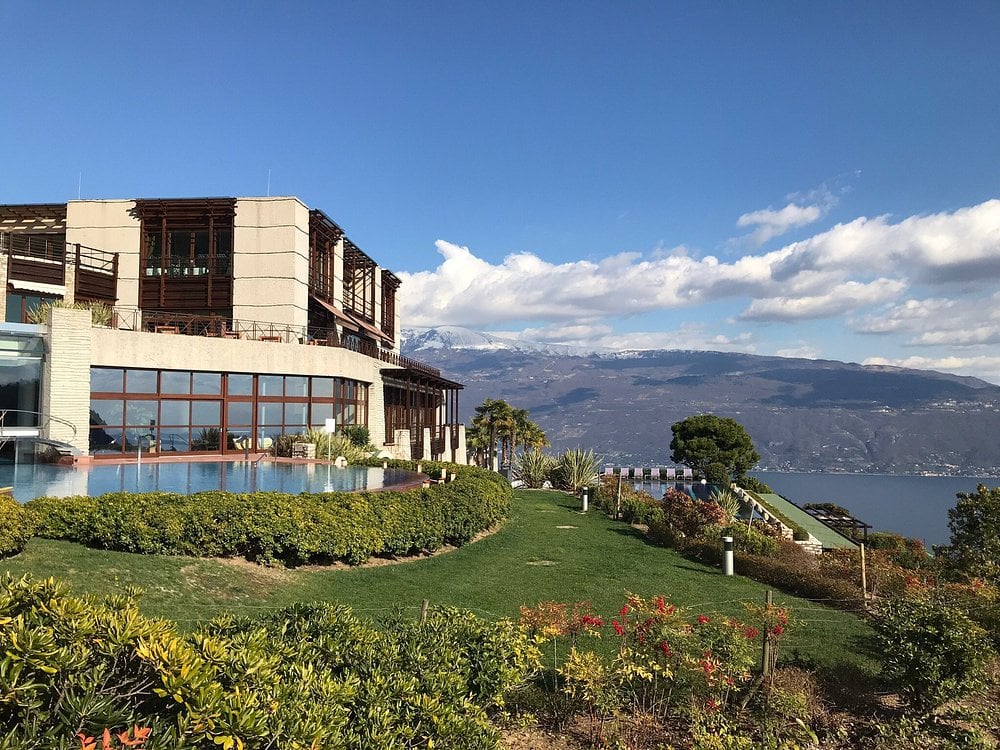 Scenic view of Lefay Resort & Spa Lago di Garda with gardens, infinity pool, and mountain backdrop.