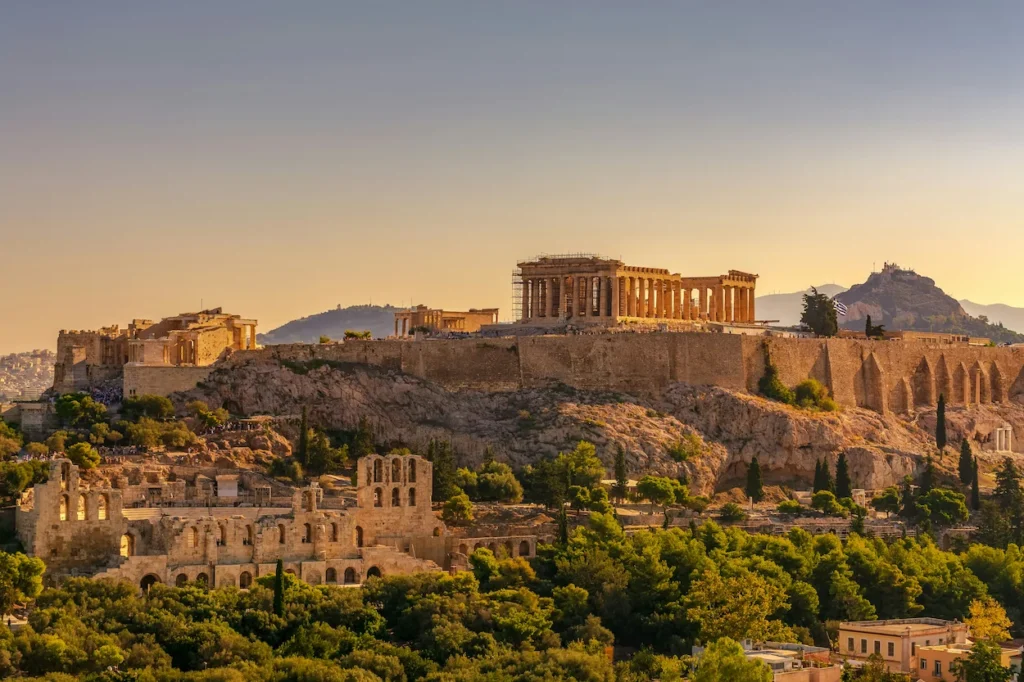 The ancient Acropolis hill and Parthenon temple under a warm sunset sky