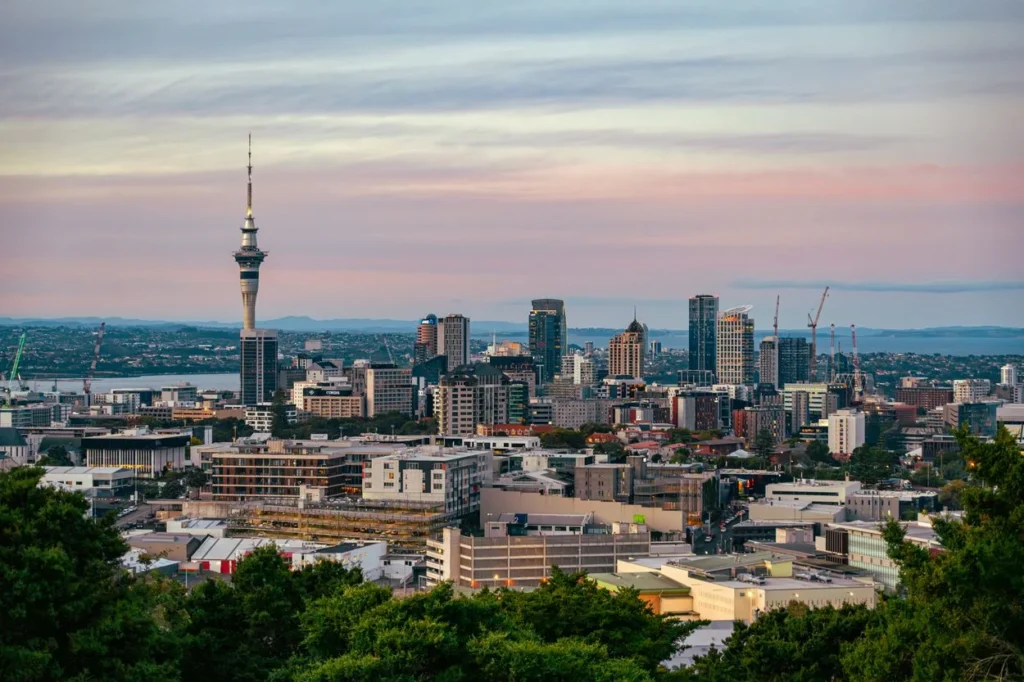Auckland skyline featuring the Sky Tower under a pastel sunset sky