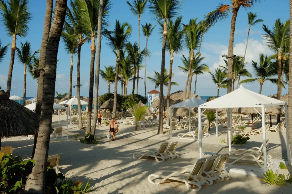 Luxury resort swimming pool and lounge chairs overlooking a white-sand beach in Cancun