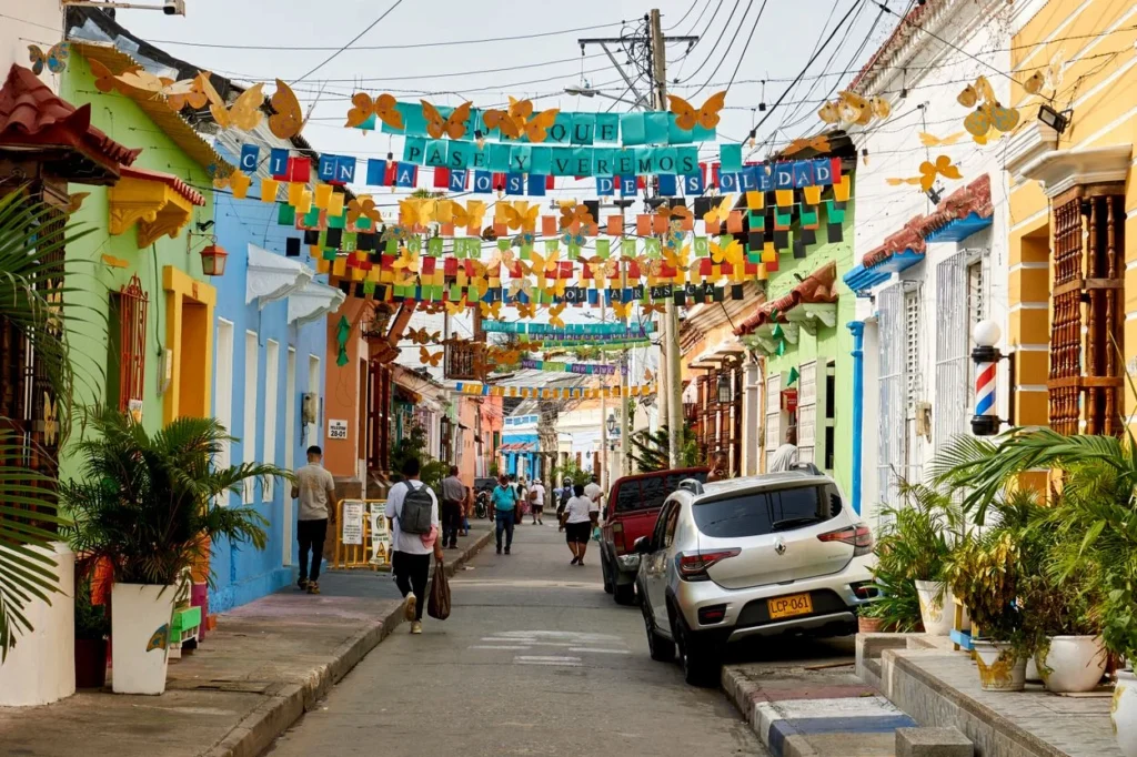 A colorful street lined with painted houses and paper decorations in Getsemaní, Cartagena